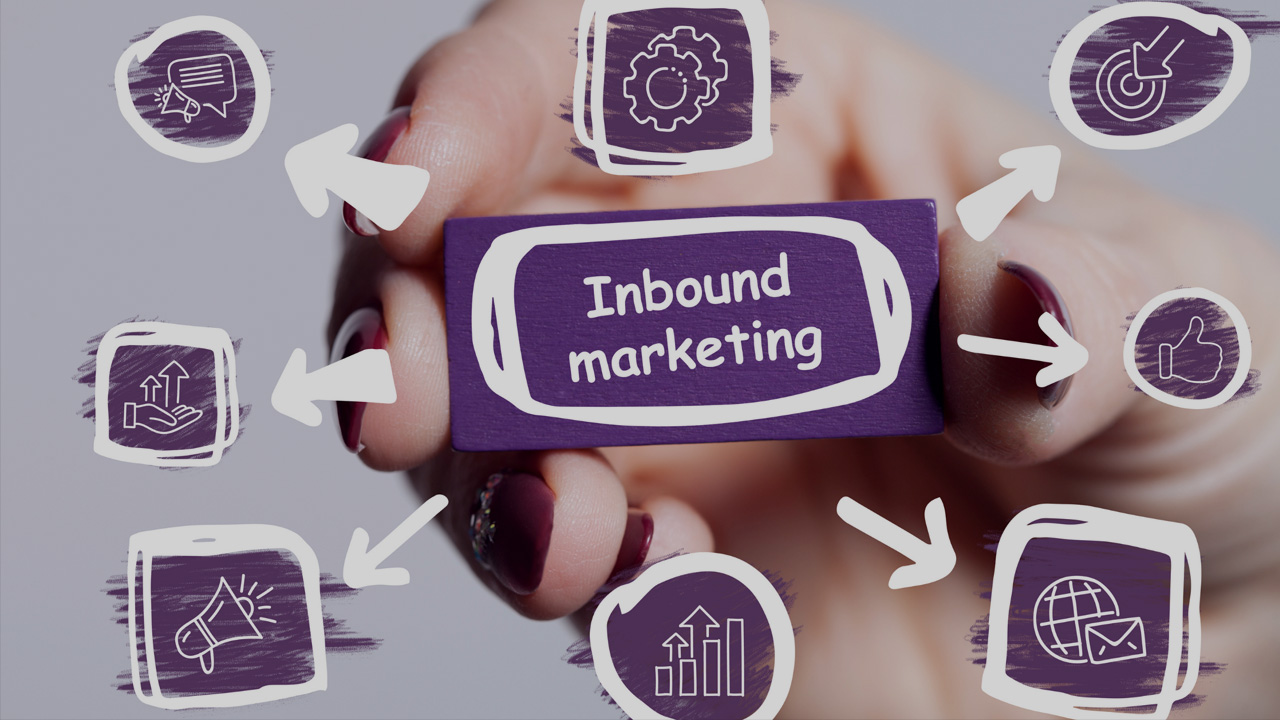 A hand holding a paper with the words "INBOUND MARKETING" on it. Arrows are drawn pointing outwards from the paper towards icon images of inbound marketing.