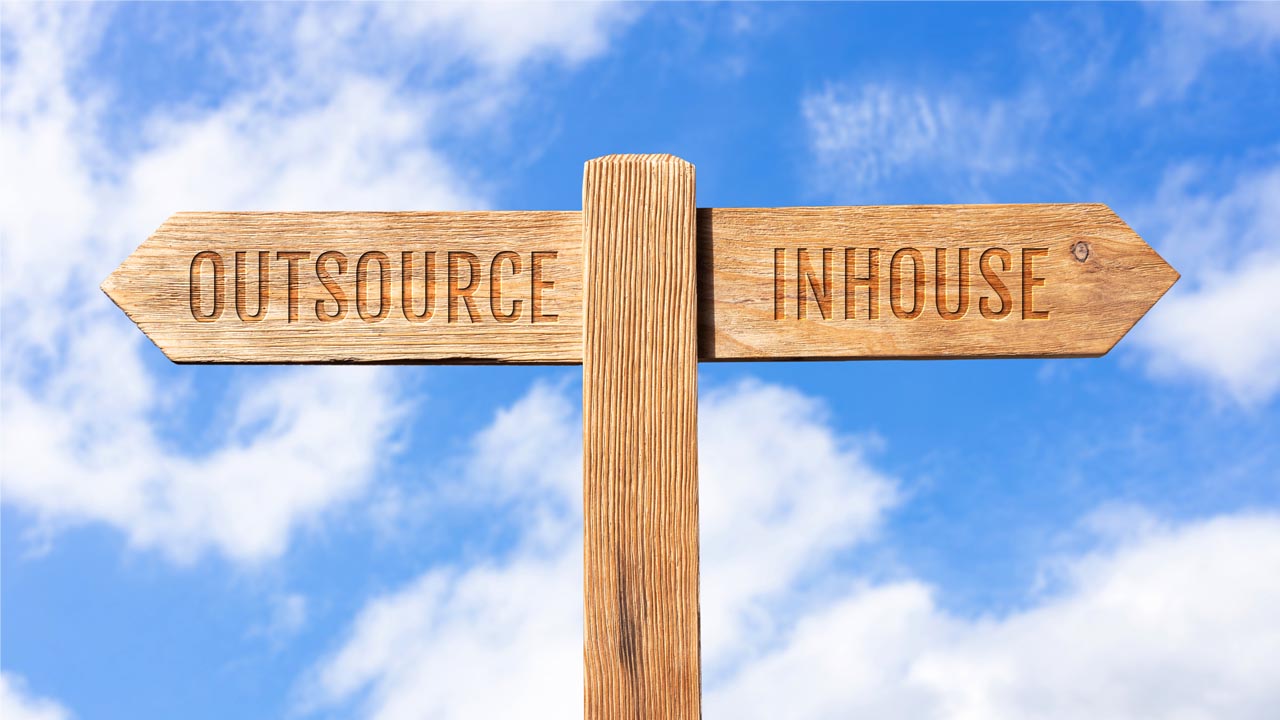 A sign pointing in two different directions. One points to the "OUTSOURCE" and the other points towards "INHOUSE".